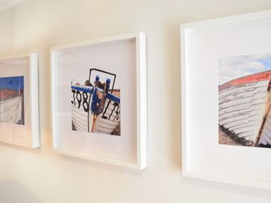Three framed pictures of boats on a white wall at 53 Tern Cottage Aldeburgh