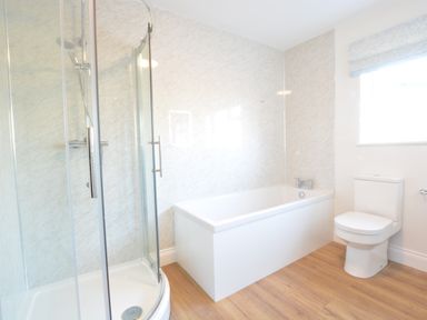 A bathroom with a corner shower, a bathtub, a toilet, and a window with a blind at Bedingfield House nr Debenham Debenham