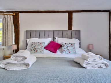 A bedroom with a double bed with pillows and folded towels at Bedingfield House nr Debenham Debenham 