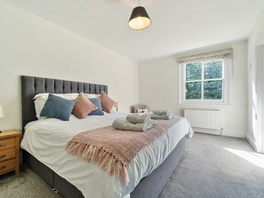 A bedroom with a large bed with pillows and towels near a window at Bedingfield House nr Debenham in Debenham