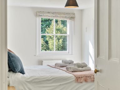 A bedroom with a bed with folded towels on a blanket under a window at Bedingfield House nr Debenham Debenham