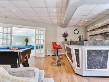A game room with a pool table red bar stools and a bar counter at Bedingfield House nr Debenham Debenham