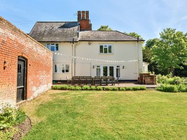 A backyard with a patio and outdoor dining table and chairs at Bedingfield House nr Debenham Debenham