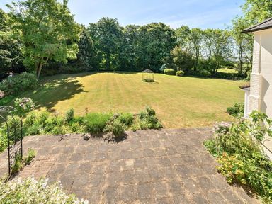 A garden with a lawn and trees surrounding it at Bedingfield House nr Debenham