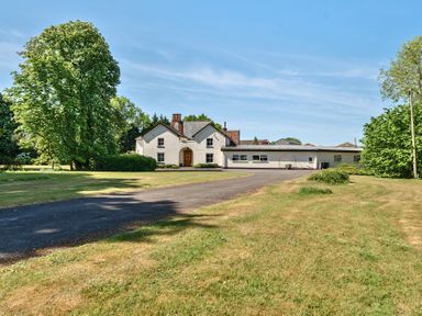 A white house with a driveway and surrounding trees and grass at Bedingfield House nr Debenham in Debenham