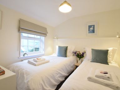 A bedroom with two single beds with white bedding and blue pillows at Seaflower Aldeburgh in Aldeburgh