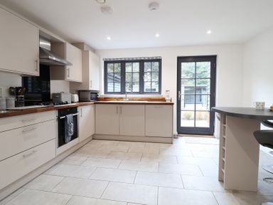 A kitchen with cabinets and appliances at Corner Cottage, Thorpeness