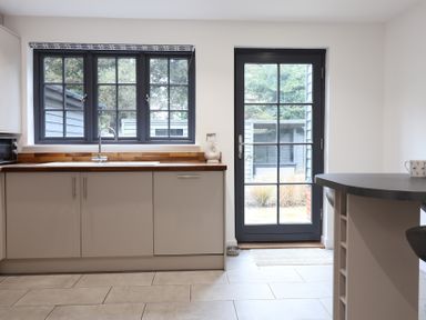 A kitchen with a sink and cabinets at Corner Cottage, Thorpeness