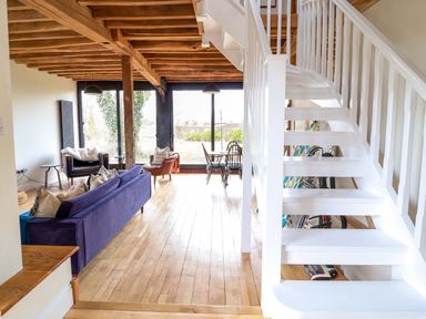A living room with a staircase and sofas at Fishpond House, Sotherton