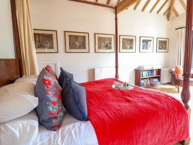 A bedroom with a four-poster bed and artwork at Fishpond House, Sotherton