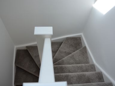 A carpeted staircase with a white handrail and gray walls at Bramertons Nest Long Melford
