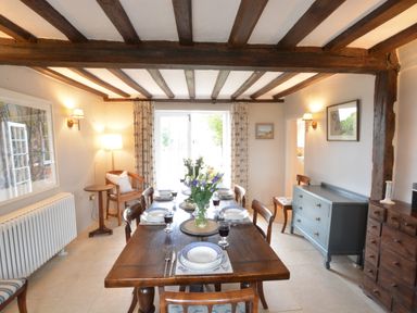 A dining room with a wooden table set for six with plates and glasses at Old Valley Farm in Walberswick