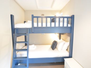 A bedroom with blue bunk beds and white bedding at Old Valley Farm in Walberswick