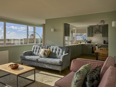A living room with a sofa and coffee table at Harbour Lights in Southwold