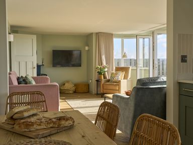 A living room with a sofa and television at Harbour Lights in Southwold