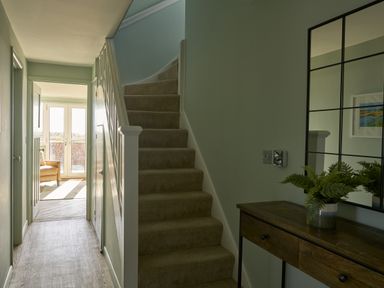 A hallway featuring a staircase and table at Harbour Lights in Southwold