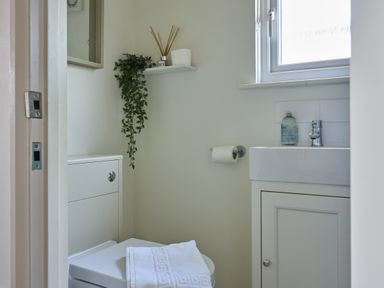 A bathroom with a toilet and sink at Harbour Lights in Southwold