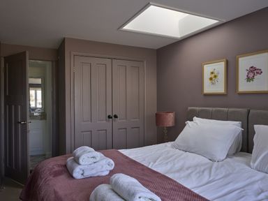 A bedroom with a bed and wardrobe at Harbour Lights in Southwold