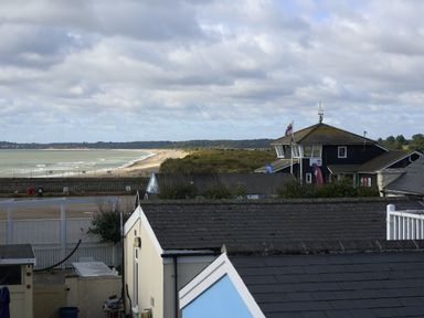 A coastal view with buildings and sand dunes at Harbour Lights Southwold