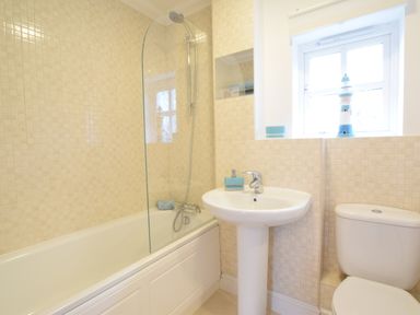 A bathroom with bathtub shower combination sink and toilet at Bluebelle Cottage Peasenhall