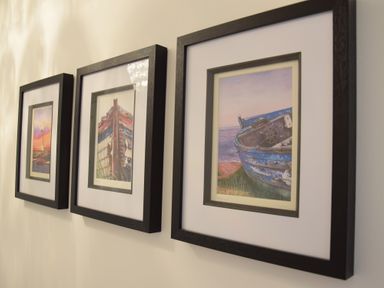 Three framed paintings of boats on a wall at Bluebelle Cottage Peasenhall