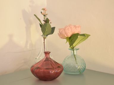 Three glass vases with artificial flowers on a tabletop at Rosedene Rickinghall
