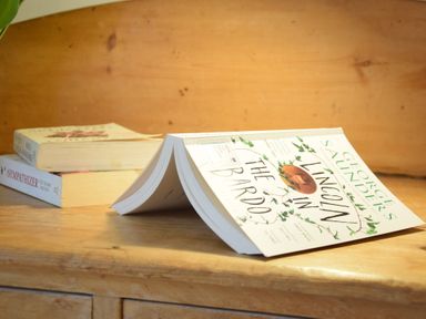 Three books on a wooden surface with one book open and two stacked at Rosedene Rickinghall