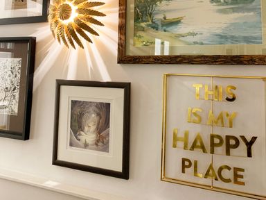 A wall with framed pictures and golden text saying this is my happy place at Cragside in Aldeburgh