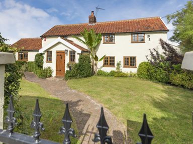 A front view of a house with tiled roof a wooden door a brick path and a lawn at Skelder Parham Parham Near Framlingham