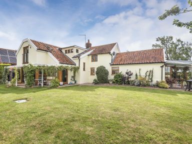 A house with a tiled roof and garden with plants and patio furniture at Skelder Parham in Parham Near Framlingham