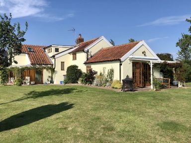 A house with a tiled roof surrounded by a garden and lawn at Skelder Parham in Parham Near Framlingham