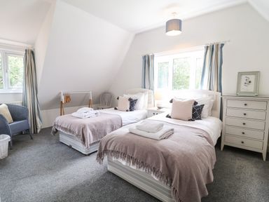 A bedroom with two single beds and a chest of drawers at High Ground Reydon in Reydon