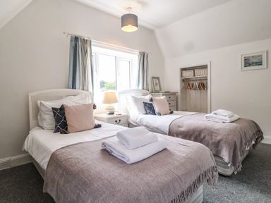 A bedroom with two single beds with pillows and folded towels on top at High Ground Reydon in Reydon