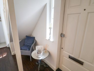 A hallway with a chair and table at High Ground, Reydon