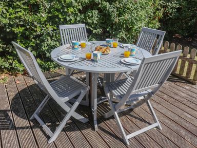 A garden dining table with cups and plates at High Ground, Reydon