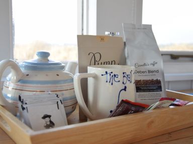 A wooden tray with a teapot mug coffee bags and tea bags on a table at The Old Fisherman's Hut in Southwold