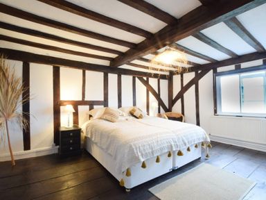 A bedroom with a double bed nightstands and a window at Church Farmhouse Cookley Near Halesworth