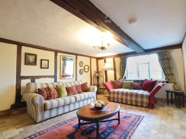 A sitting room with two sofas a wooden coffee table and framed pictures on the wall at Church Farmhouse Cookley Near Halesworth