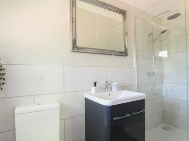 A bathroom with a toilet sink shower and a mirror at The Piglets in Newbourne Near Woodbridge