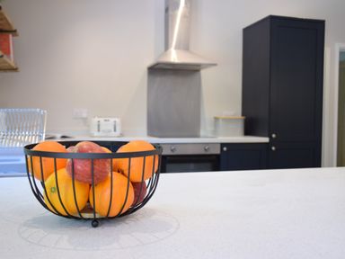 A kitchen countertop with a fruit bowl containing oranges and apples at The Piglets in Newbourne Near Woodbridge