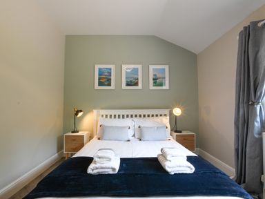 A bedroom with a bed and folded towels at The Piglets in Newbourne Near Woodbridge