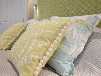 Close up of decorative pillows on a bed with patterned headboard at Regatta Lookout in Aldeburgh