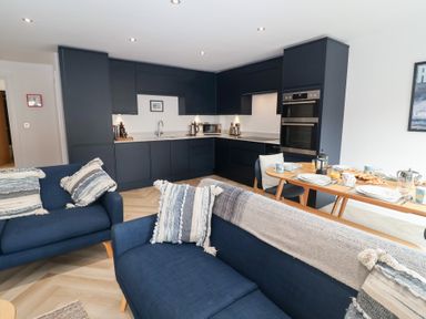 A kitchen with couches and dining set at Salt Marsh House, Southwold