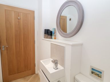 A bathroom with a sink and mirror at Salt Marsh House, Southwold