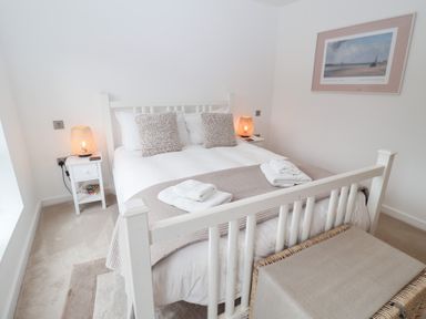 A bedroom with a bed and bedside table at Salt Marsh House, Southwold