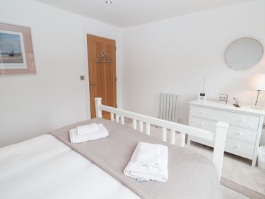 A bedroom with a bed and dresser at Salt Marsh House, Southwold