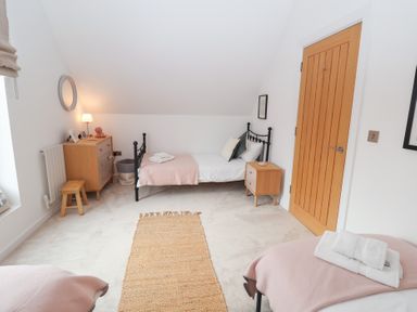 A bedroom with two beds and a dressing table at Salt Marsh House, Southwold