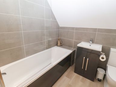 A bathroom with a bathtub and sink at Salt Marsh House, Southwold