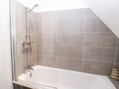 A bathroom with a bathtub and shower at Salt Marsh House, Southwold