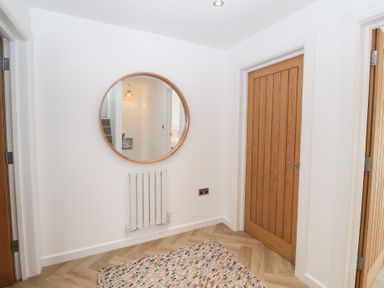A hallway with a mirror and radiator at Salt Marsh House, Southwold